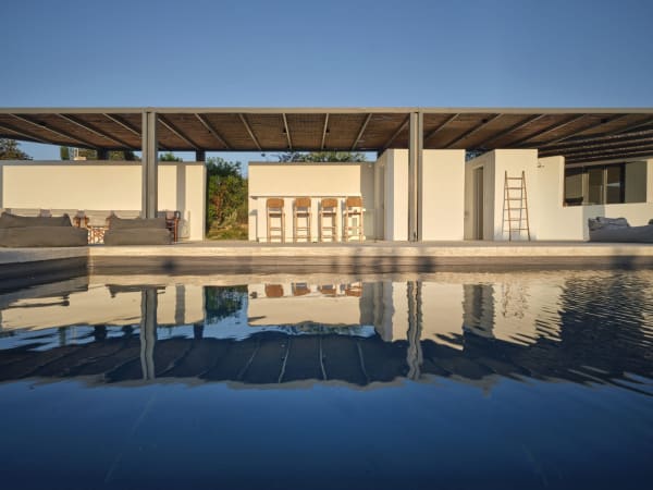Flanking the pool is a large shaded area with dining table, built-in seating, a bar and a barbecue.